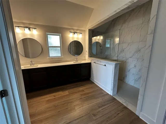 a room with a sink cabinets and a mirror