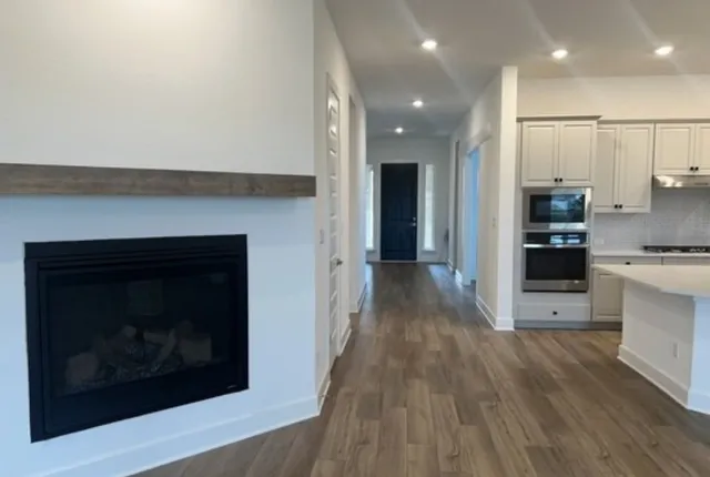a view of a kitchen with a sink a refrigerator and a fireplace