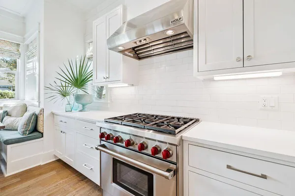 a large kitchen with stainless steel appliances a sink a counter top space and a window