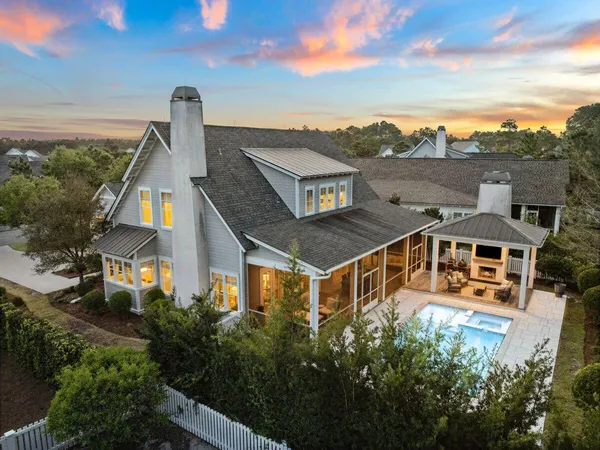 an aerial view of a house with a big yard and large trees