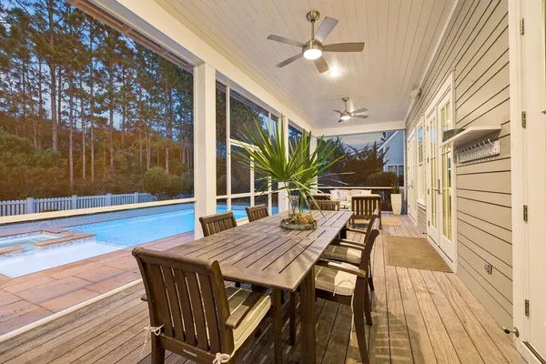 a view of a patio with table and chairs with wooden floor and floor to ceiling window