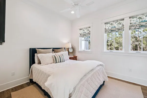 a bedroom with a bed and a flat tv screen on the dresser