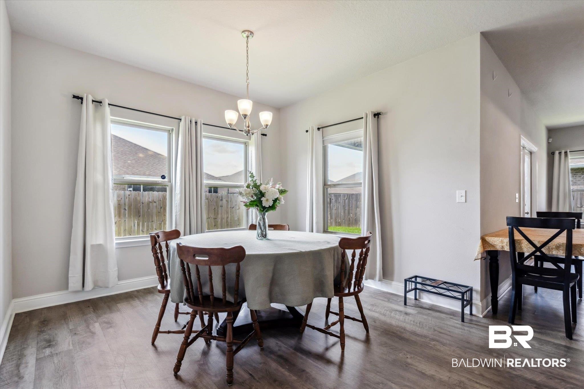 10501 Loamy Avenue Mobile, AL 36695 - Photo 11 of 30 Dining room with dark hardwood / wood-style flooring, a notable chandelier, and a healthy amount of sunlight