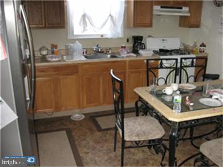 605-607 Filmore Street Riverside, NJ 08075 - Photo 7 of 7 a kitchen with a table chairs and a refrigerator