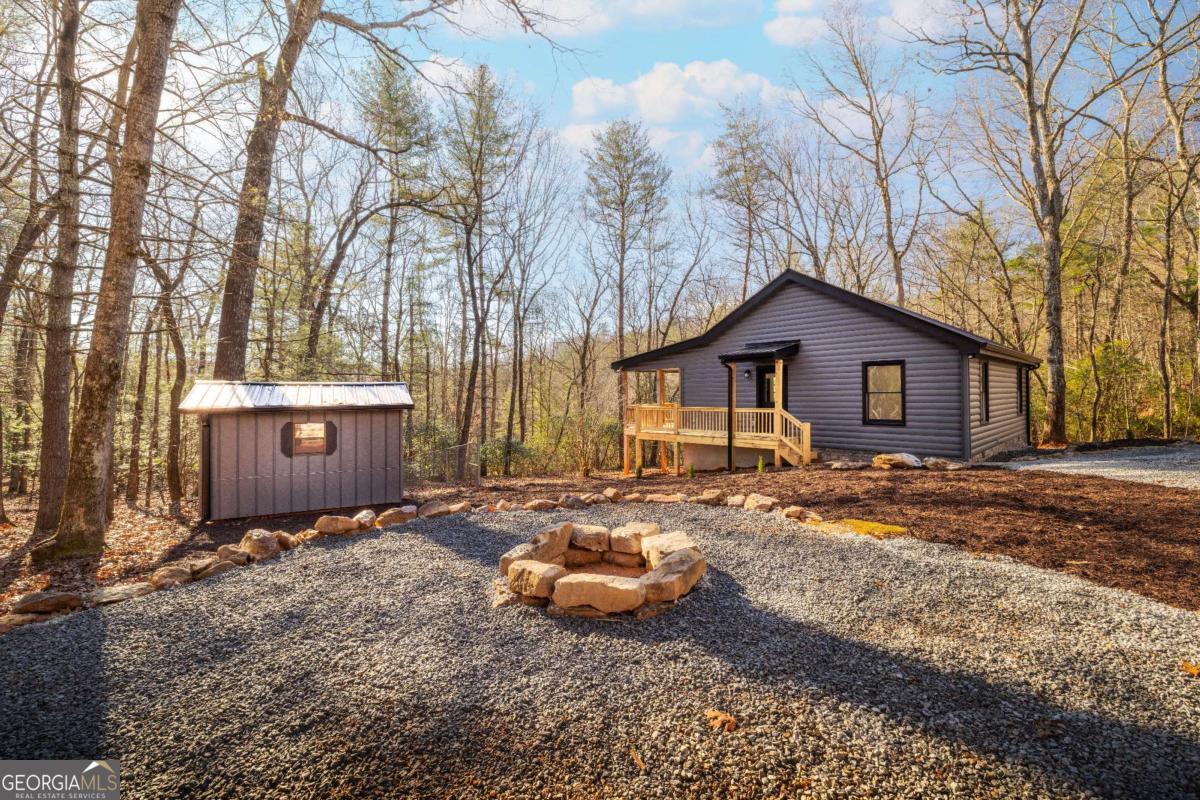 a backyard of a house with barbeque oven and outdoor seating