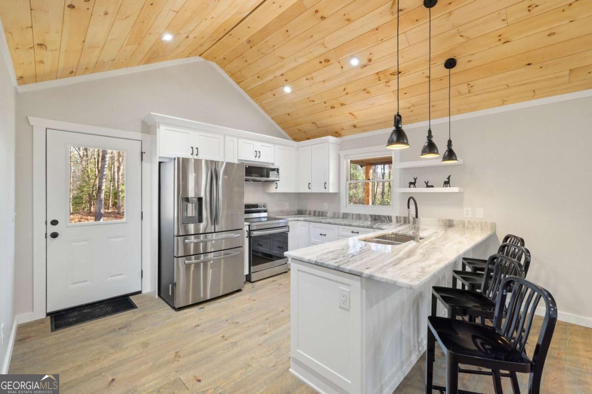 292 Wits End Way Cherry Log, GA 30522 - Photo 3 of 32 a kitchen with refrigerator cabinets and wooden floor