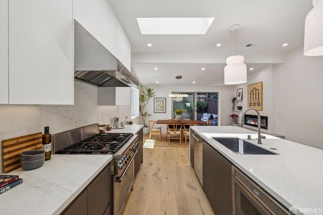 a kitchen that has a lot of cabinets a sink and a stove in it