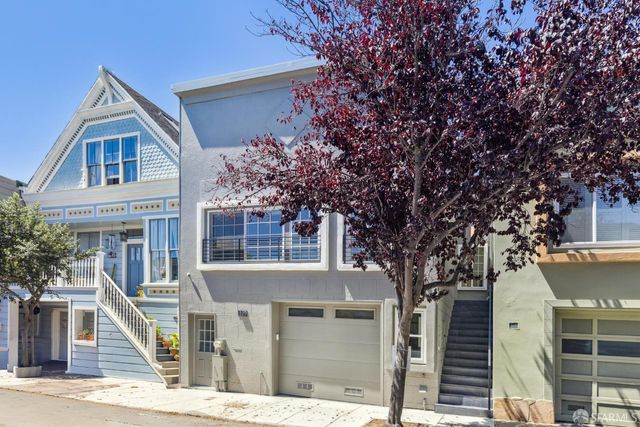 a front view of a house with a tree