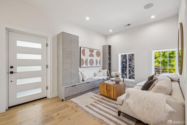 a spacious bedroom with a bed a couch and large window