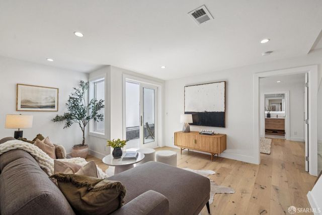 a view of a wooden house with a small yard and wooden fence