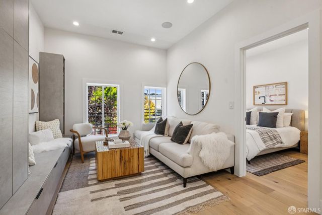 a living room with furniture a large window and a chandelier