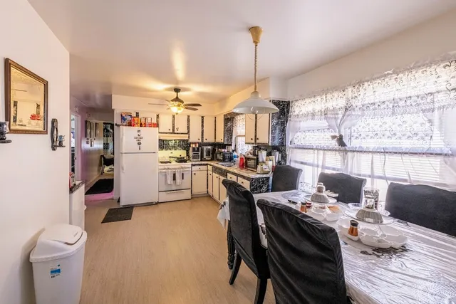 a open kitchen with stainless steel appliances kitchen island granite countertop a stove a sink dishwasher and a dining table with cabinets