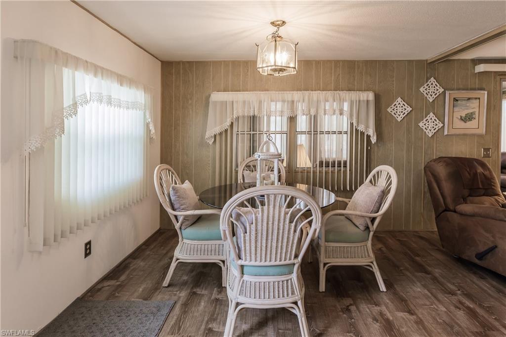 10100 Burnt Store Road, Unit 104 Punta Gorda, FL 33950 - Photo 16 of 46 Dining space with and luxury vinyl plank flooring, wood walls, and inviting lighting
