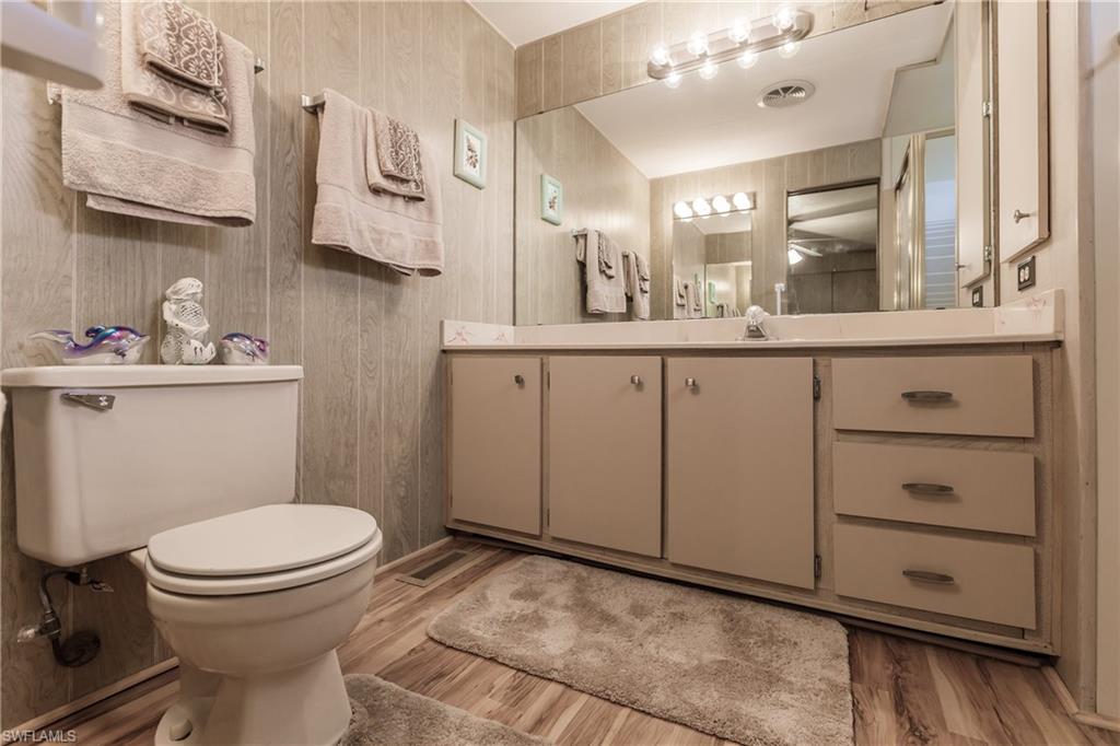 10100 Burnt Store Road, Unit 104 Punta Gorda, FL 33950 - Photo 21 of 46 Bathroom featuring laminate flooring, vanity, and toilet