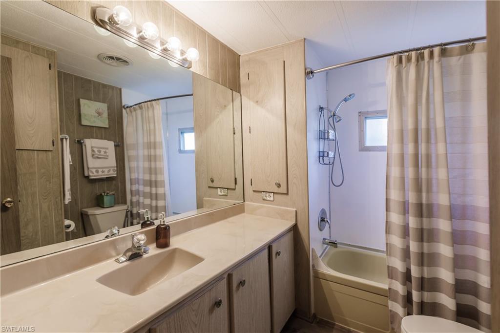 10100 Burnt Store Road, Unit 104 Punta Gorda, FL 33950 - Photo 26 of 46 Full bathroom featuring vanity, shower / tub combo, and toilet