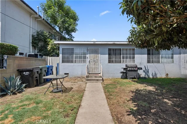 a view of a house with backyard and sitting area