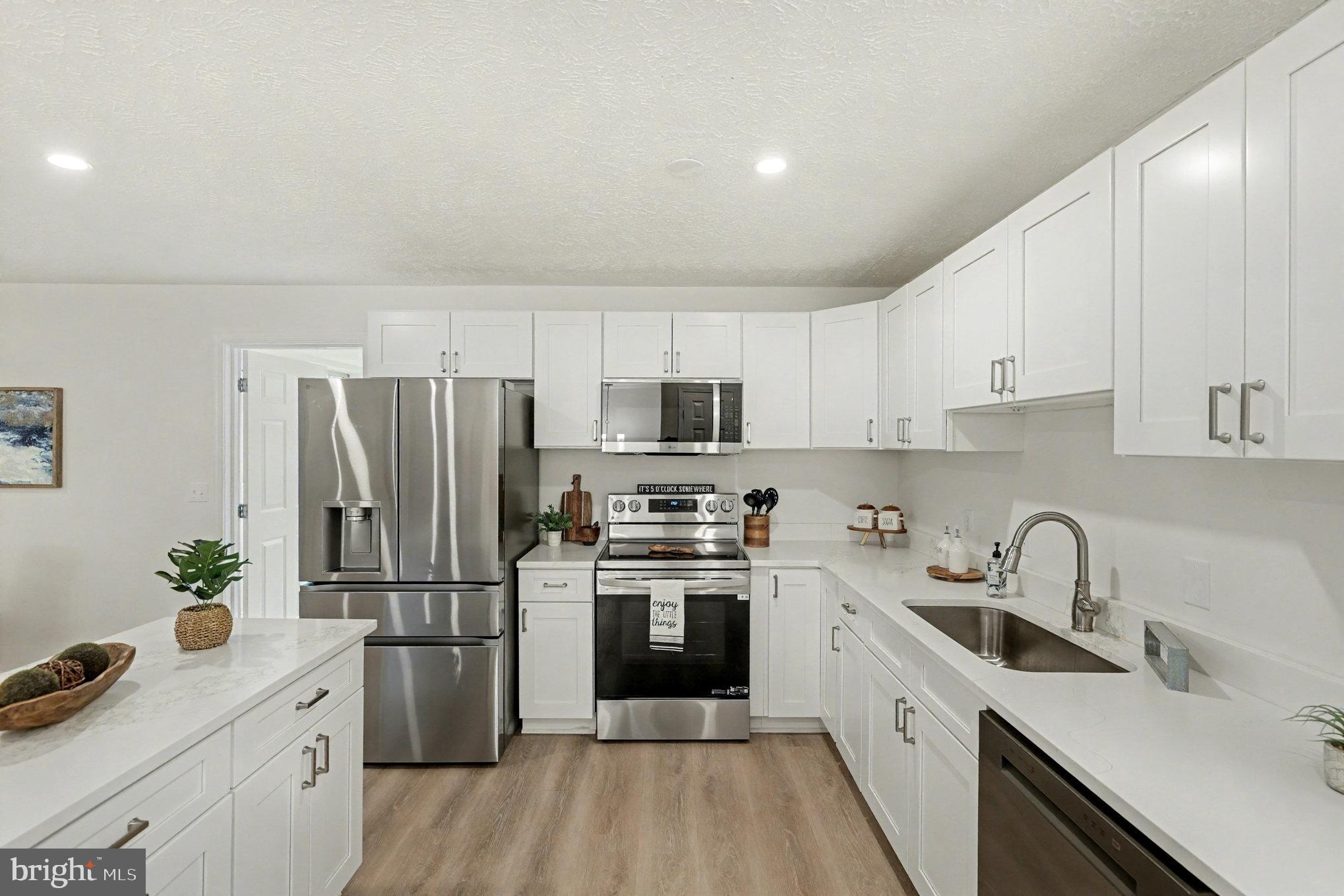 305 Green Street Locust Grove, VA 22508 - Photo 2 of 25 a kitchen with a refrigerator sink and white cabinets