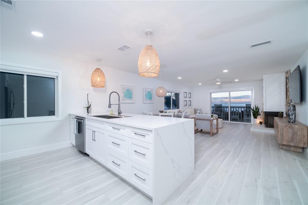 1104 Beach Trail, Unit 1 Indian Rocks Beach, FL 33785 - Photo 11 of 24 a large white kitchen with a large island oven a stove and a wooden floors