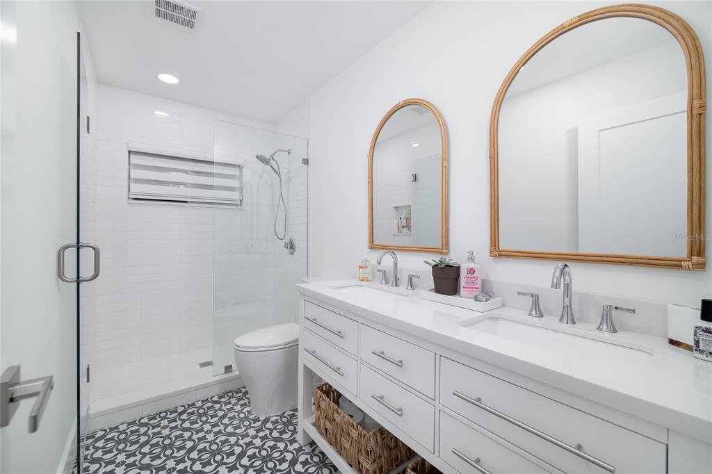 1104 Beach Trail, Unit 1 Indian Rocks Beach, FL 33785 - Photo 12 of 24 a bathroom with a double vanity sink toilet and a mirror