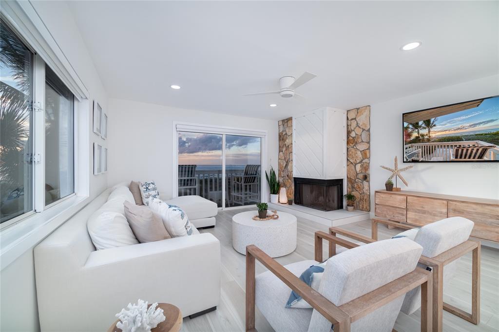 1104 Beach Trail, Unit 1 Indian Rocks Beach, FL 33785 - Photo 3 of 24 a living room with furniture a fireplace and a floor to ceiling window