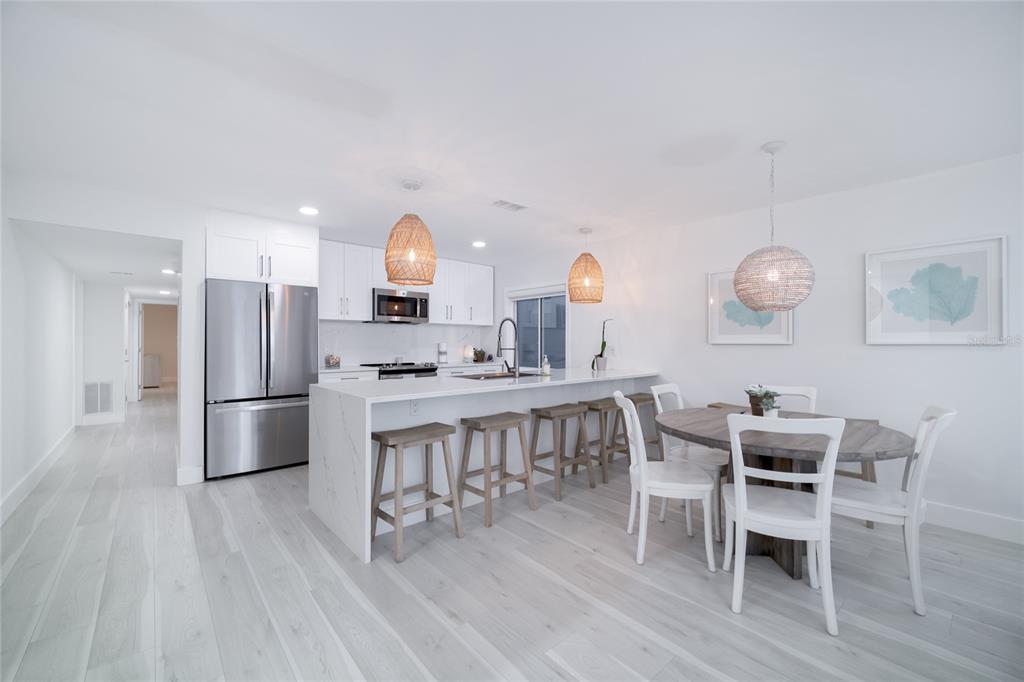 1104 Beach Trail, Unit 1 Indian Rocks Beach, FL 33785 - Photo 7 of 24 a kitchen with a dining table chairs and refrigerator