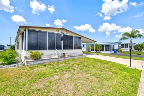 a view of a house with backyard and sitting area