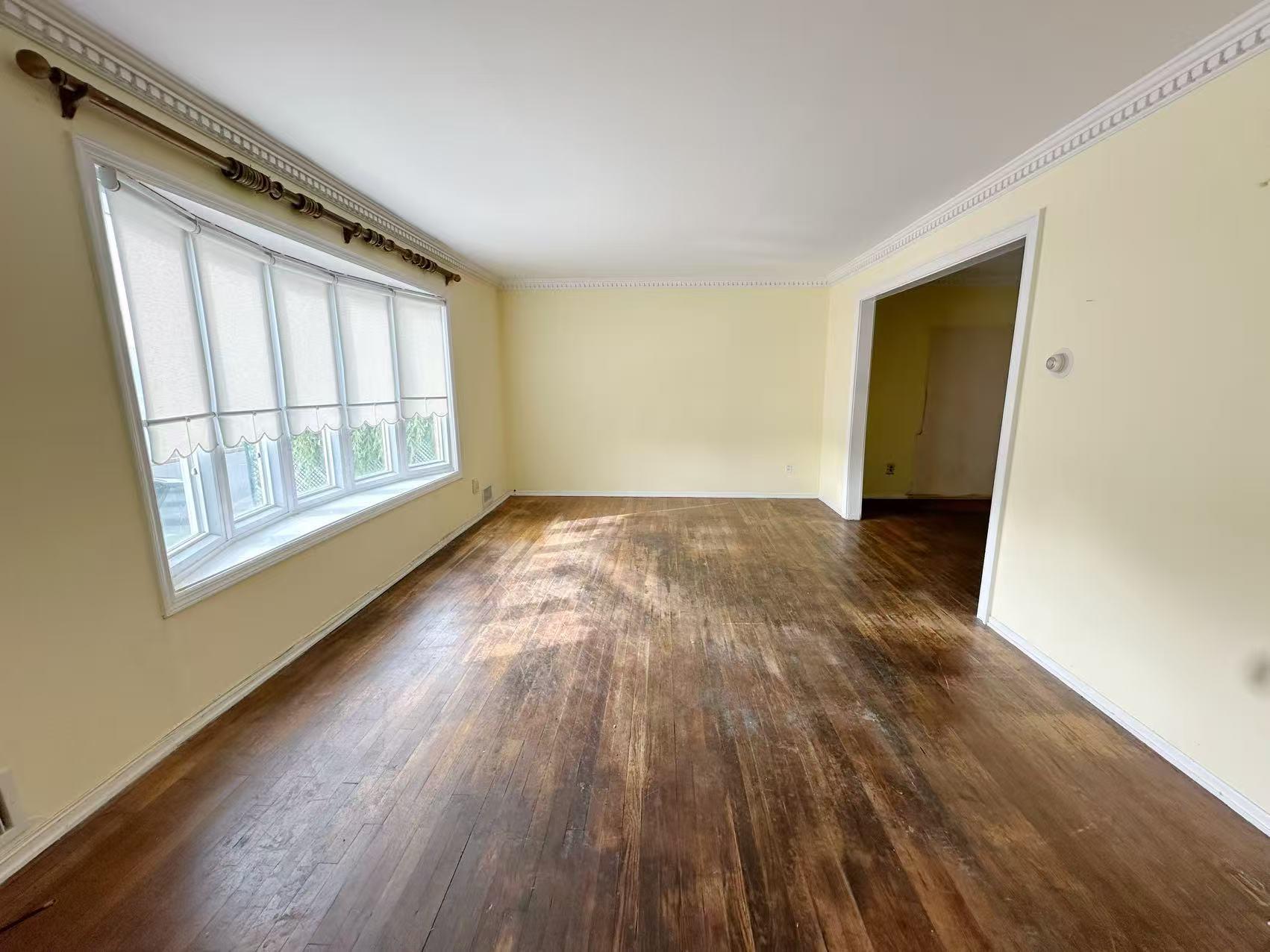 23-11 Whitestone Expressway Queens, NY 11357 - Photo 7 of 10 a view of an empty room with wooden floor and a window