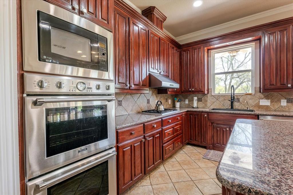 166 East Rio Ridge Azle, TX 76020 - Photo 14 of 40 a kitchen with stainless steel appliances granite countertop a stove microwave and sink