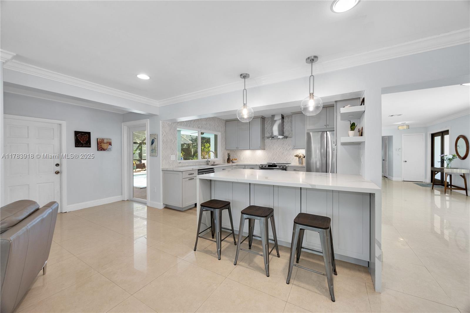 9401 Southwest 69th Court Pinecrest, FL 33156 - Photo 28 of 39 a kitchen with kitchen island a dining table chairs cabinets and a sink