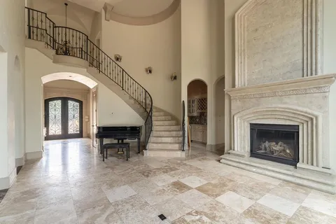 a view of hall with wooden floor and a fireplace