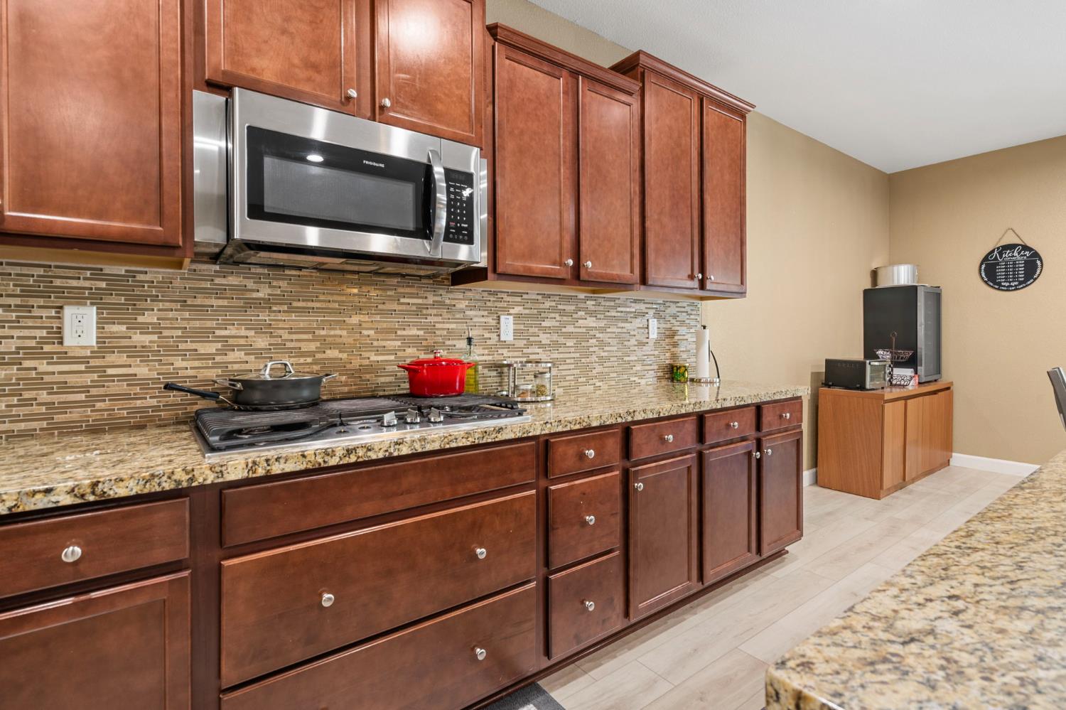 2317 Mathar Drive Manteca, CA 95337 - Photo 15 of 48 a kitchen with granite countertop wooden cabinets and stainless steel appliances