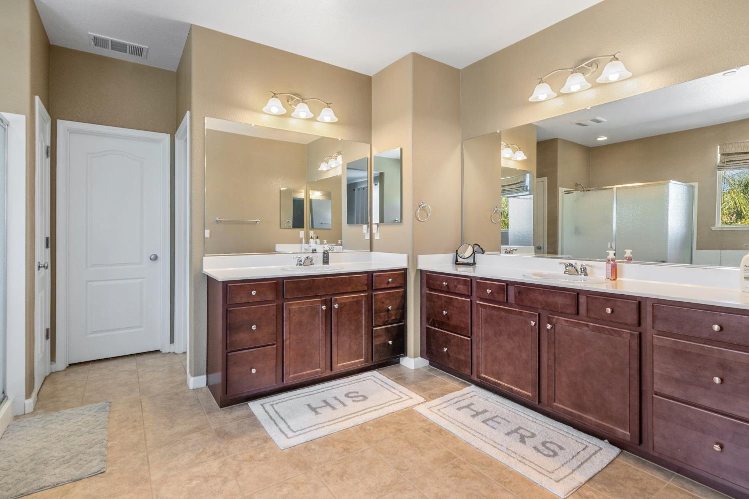 2317 Mathar Drive Manteca, CA 95337 - Photo 31 of 48 a spacious bathroom with a vanity a sink a large mirror and a shower
