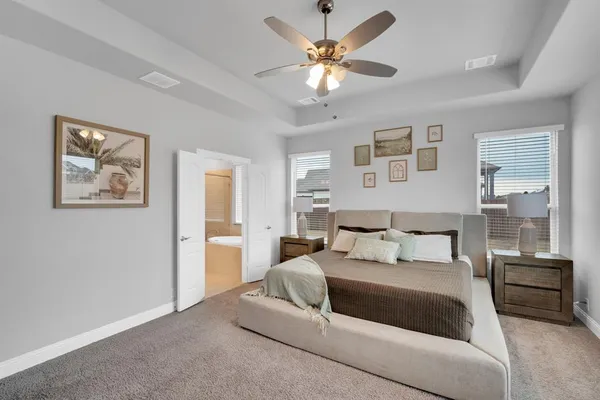 a bedroom with a large bed and a chandelier