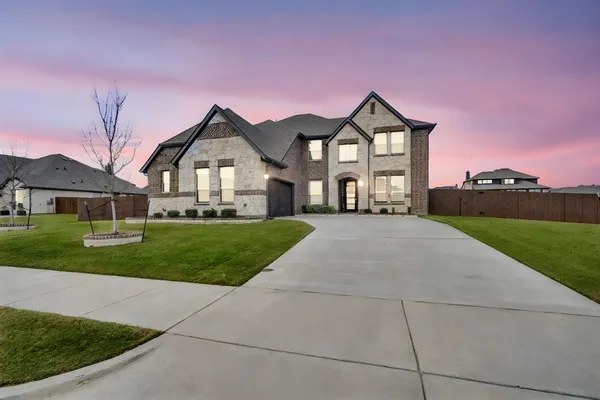 a front view of a house with yard and green space
