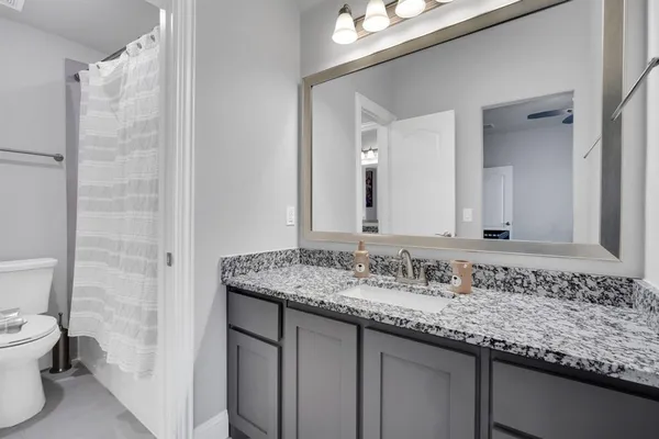 a bathroom with a granite countertop sink and a mirror