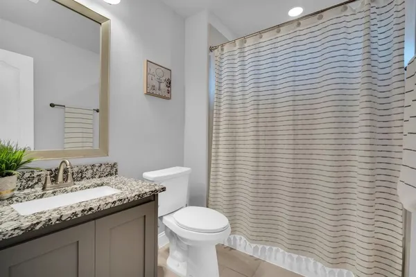 a bathroom with a granite countertop toilet and sink