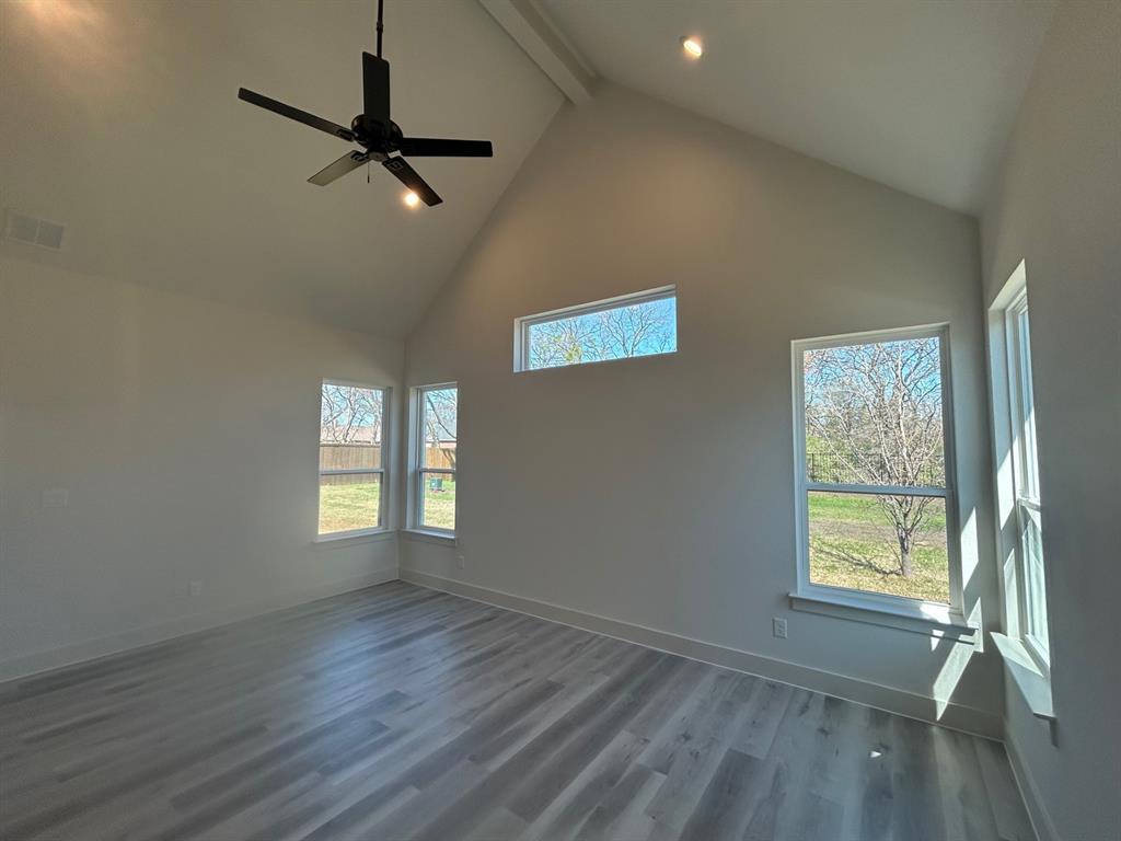 415 East Burks Street Pilot Point, TX 76258 - Photo 8 of 13 a view of an empty room with a window and wooden floor