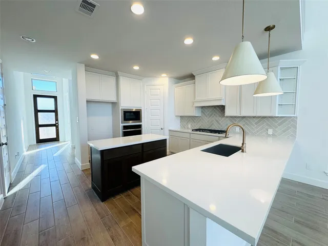 a kitchen with a sink stove and cabinets