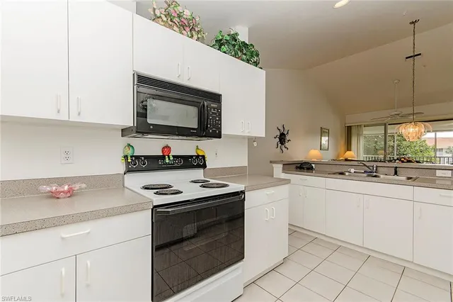 a kitchen with granite countertop a sink and white cabinets