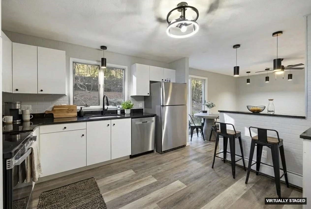 28 Long Hill Road Brookfield, MA 01506 - Photo 3 of 37 a kitchen with a table chairs refrigerator and cabinets