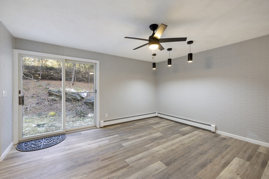 28 Long Hill Road Brookfield, MA 01506 - Photo 7 of 40 an empty room with wooden floor fan and windows