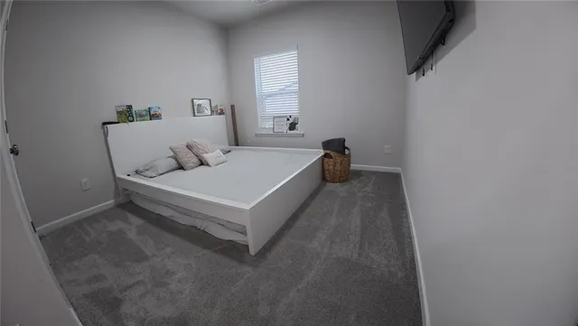 a spacious bedroom with a bed and window