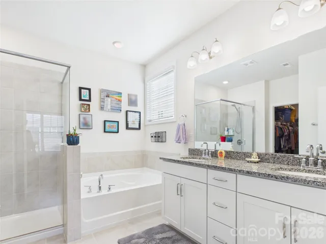 a bathroom with sink bathtub and double vanity
