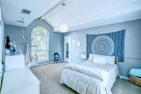 a bedroom with a bed and a large window