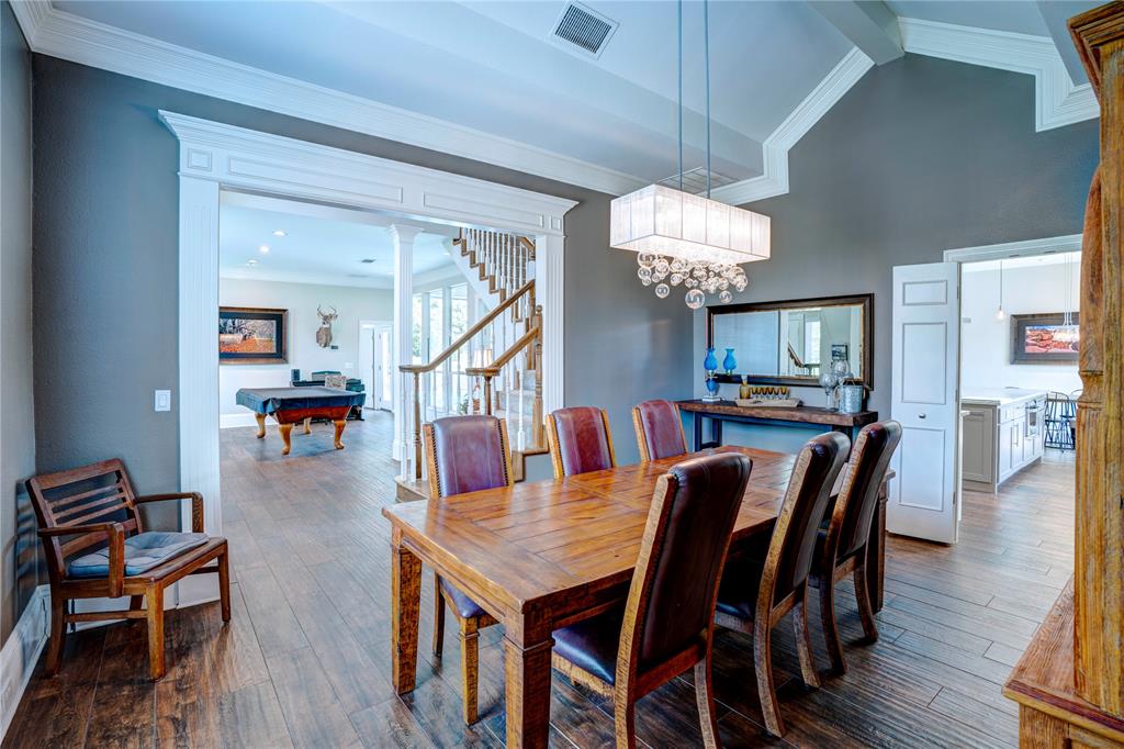800 Woodcrest Court Southlake, TX 76092 - Photo 5 of 40 a dining room with wooden floor a chandelier a wooden table and chairs