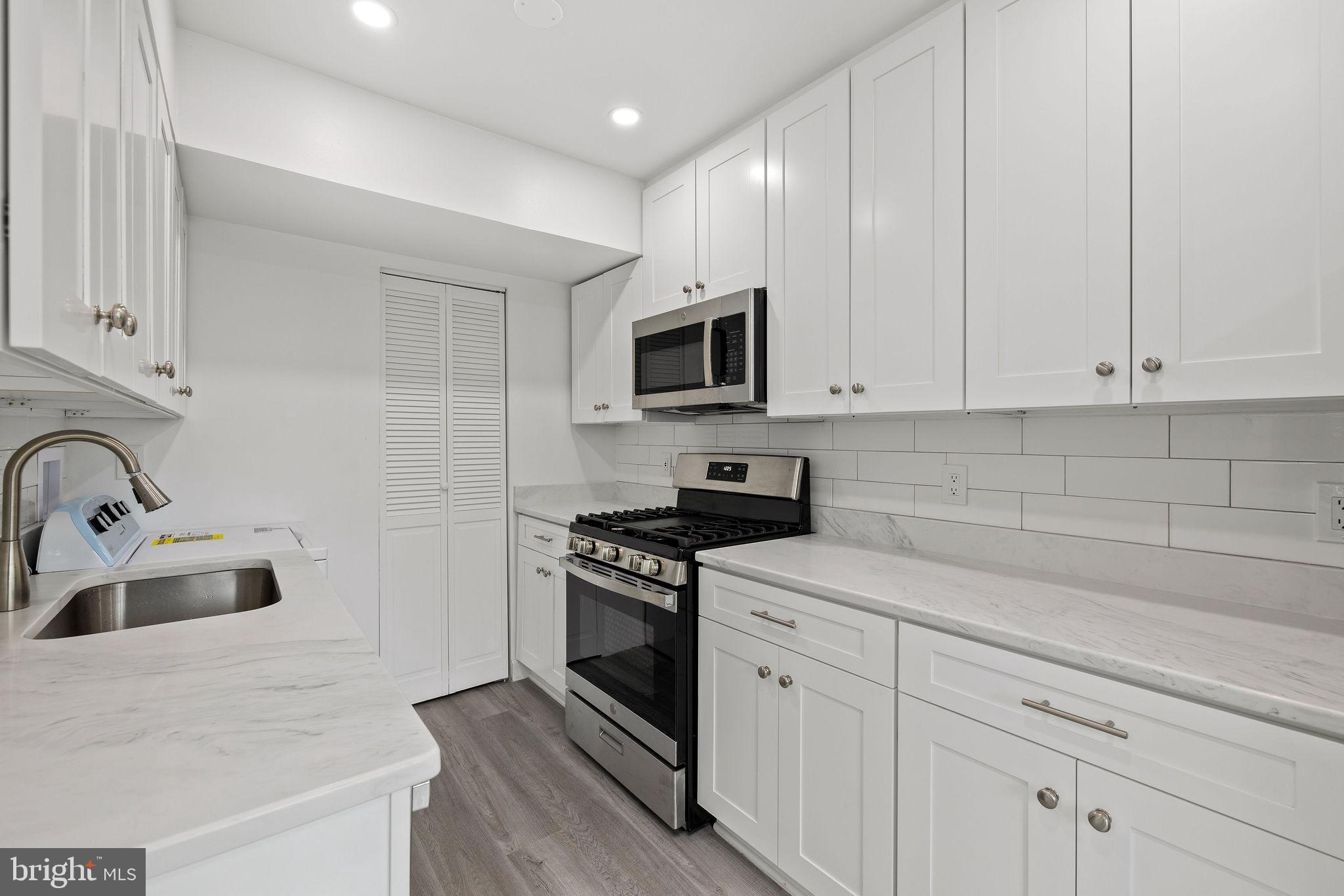8157 Community Drive Manassas, VA 20109 - Photo 20 of 37 a kitchen with white cabinets stainless steel appliances and sink