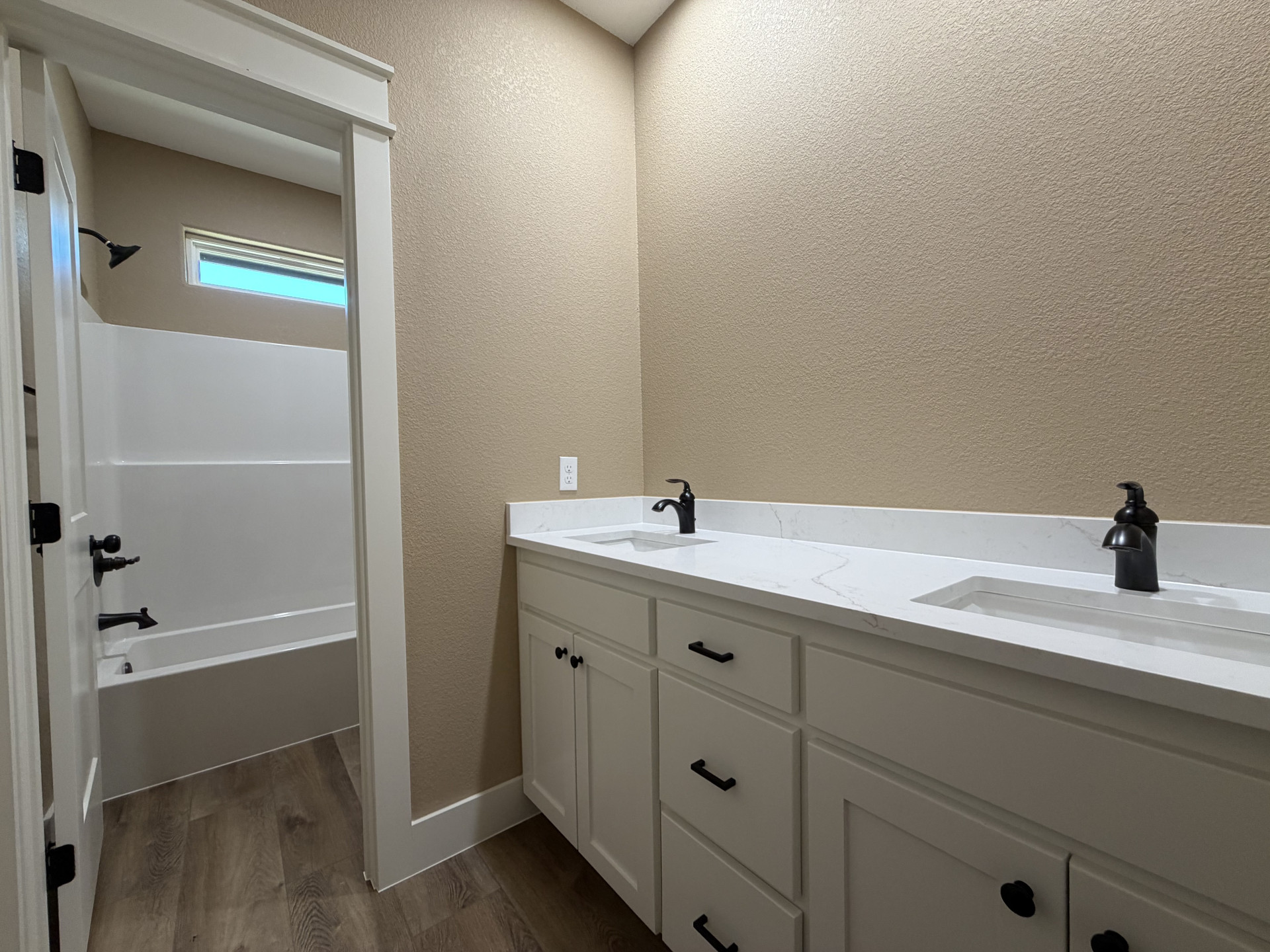 33 Wilderness Road North Calera, OK 74730 - Photo 21 of 39 Double vanity with integrated sinks, white cabinetry, matte black hardware, and wood-finish flooring