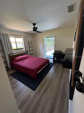 a porch with a table chairs and a floor to ceiling window