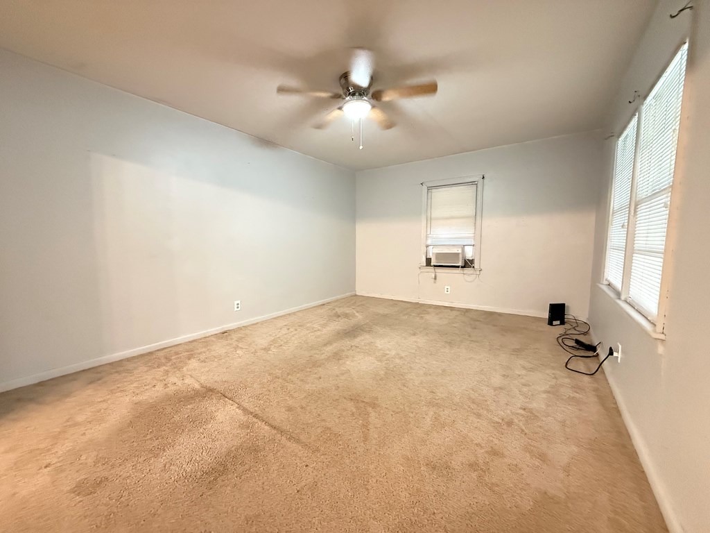 4221 Adams Street Columbus, GA 31907 - Photo 6 of 17 an empty room with a chandelier fan and windows