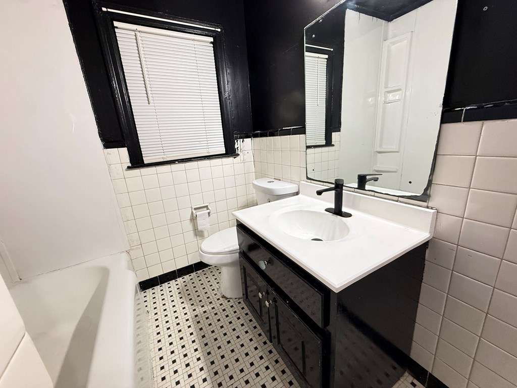 4221 Adams Street Columbus, GA 31907 - Photo 10 of 17 a bathroom with a sink a toilet a mirror and vanity